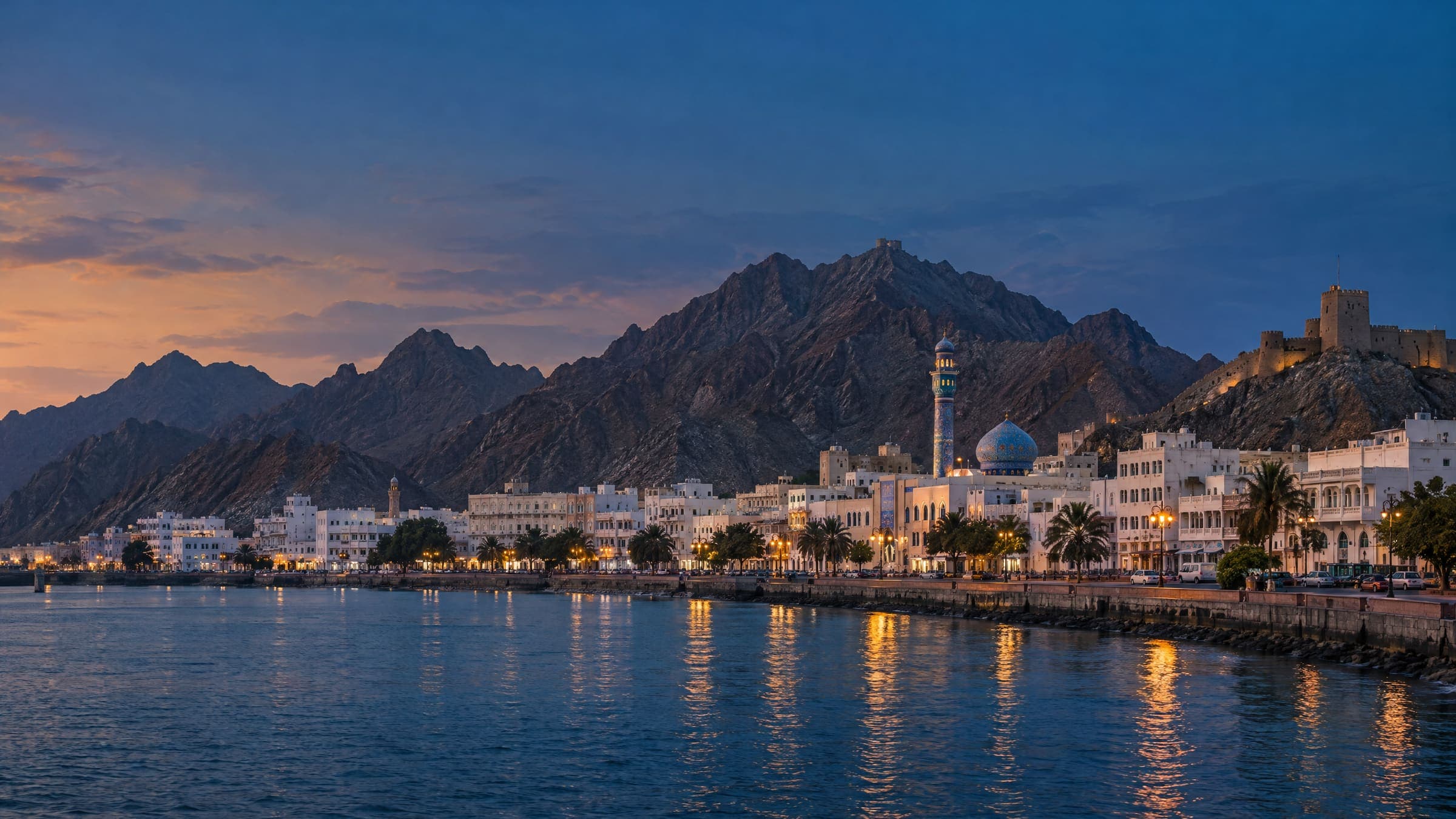 Low white buildings of Muscat between the mountains and the sea